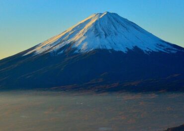 Scenic view of Mount Fuji with surrounding lakes and forests, showcasing Japan’s iconic landscape