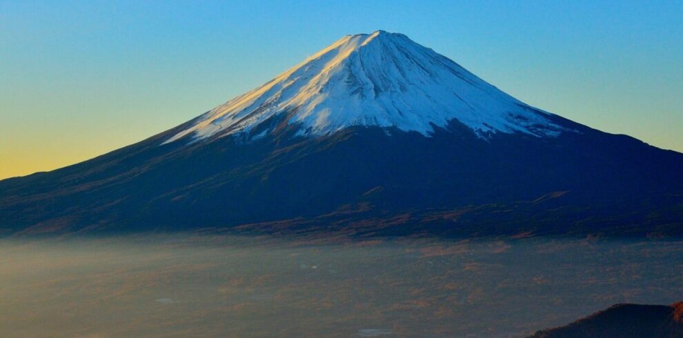 Scenic view of Mount Fuji with surrounding lakes and forests, showcasing Japan’s iconic landscape